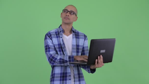 Glücklicher, glatzköpfiger Hipster, der mit Laptop denkt — Stockvideo