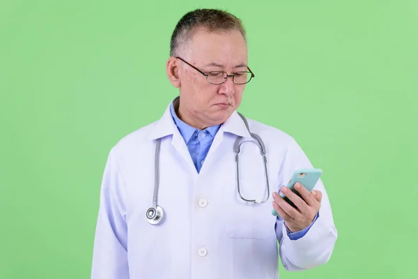 Зрелый японский врач в очках по телефону — стоковое фото
