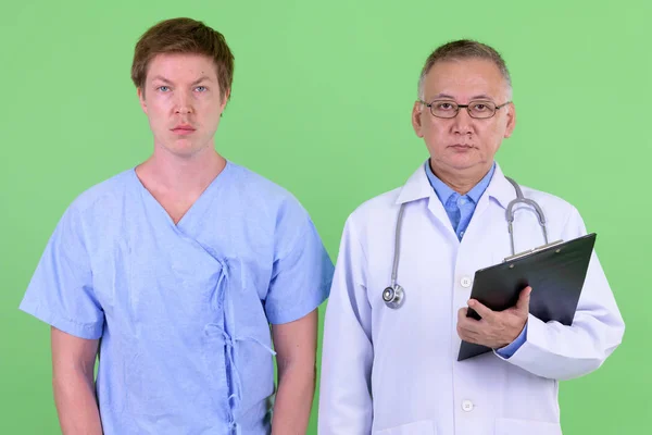 Maduro japonês homem médico com escandinavo homem paciente juntos — Fotografia de Stock