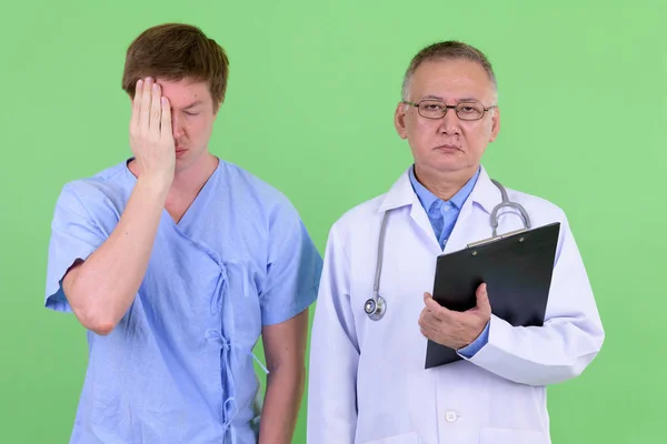 Зрелый японский врач со скандинавским пациентом получает плохие новости вместе — стоковое фото