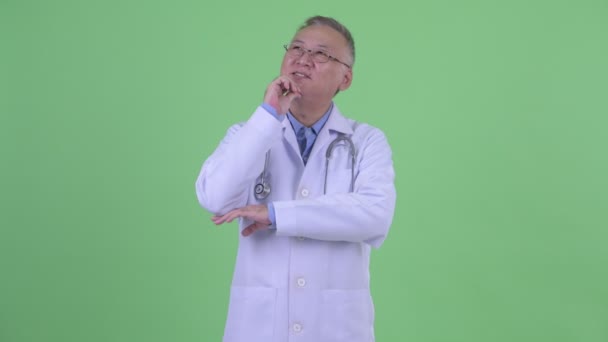 Feliz madura japonesa hombre médico pensando — Vídeos de Stock