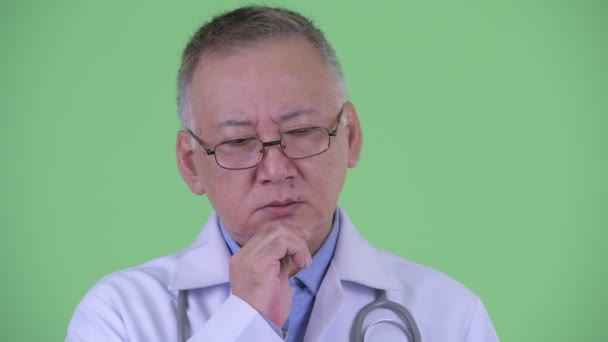 Face of stressed mature Japanese man doctor thinking — Stock Video