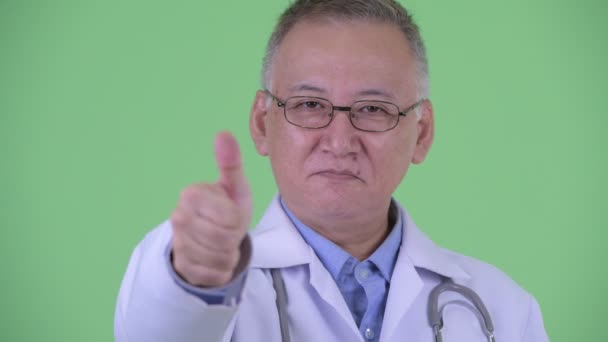 Tvář šťastně zralého japonského doktora, který dává palce — Stock video
