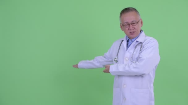 Estresado maduro japonés hombre médico presentando a la espalda — Vídeos de Stock