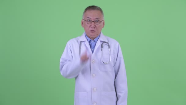 Angry mature Japanese man doctor with finger on lips — Stock Video