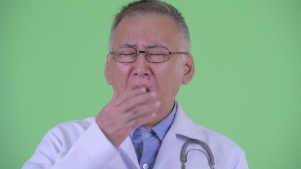 Face of tired mature Japanese man doctor yawning — Stock Video