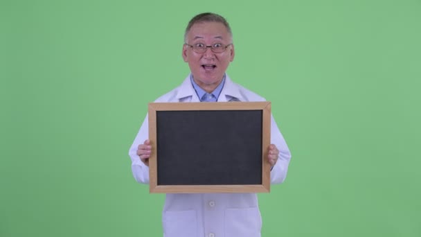 Happy Mature Japanese Man Doctor Looking Surprised While Holding Blackboard Video By C Amazingmikael Stock Footage Happy Mature Japanese Man Doctor Looking Surprised While Holding Blackboard Video By C Amazingmikael Stock Footage