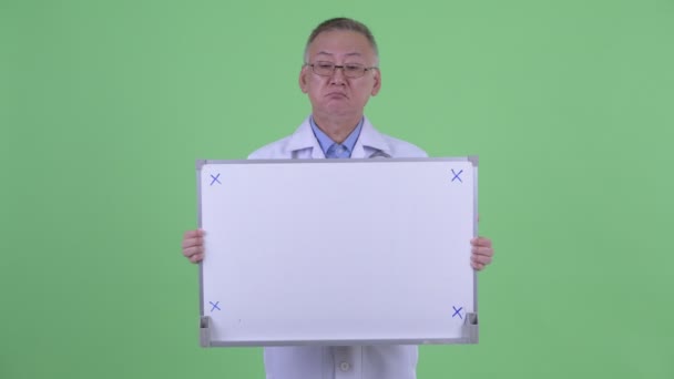 Estressado maduro japonês homem médico segurando branco bordo — Vídeo de Stock