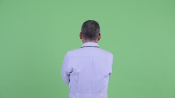 Visão traseira do homem japonês maduro médico apontando o dedo e dirigindo — Vídeo de Stock