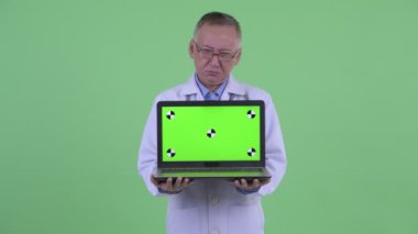 Stresli olgun Japon adam doktor dizüstü gösteren