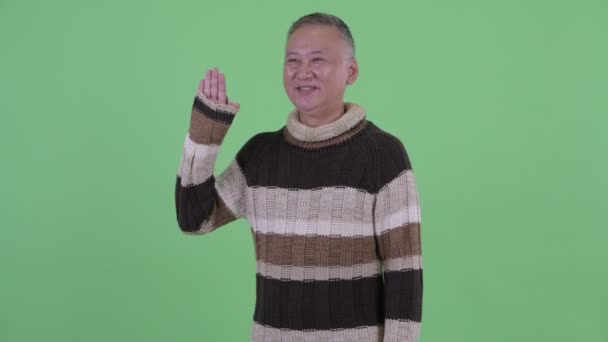 Happy mature Japanese man waving hand ready for winter — Stock Video