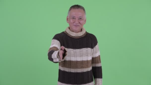 Happy mature Japanese man giving handshake ready for winter — Stock Video