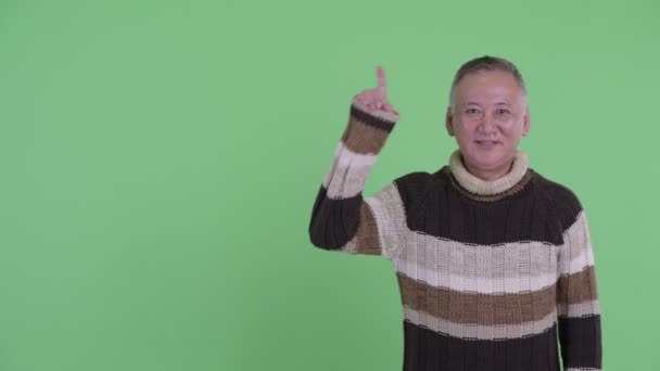 Lycklig mogen japansk man tänkande medan pekar upp — Stockvideo