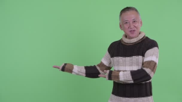 Szczęśliwy dojrzały Japoński mężczyzna mówienie podczas pokaz coś — Wideo stockowe