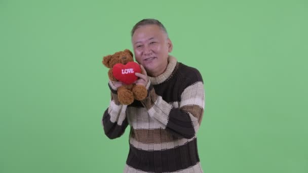 Lycklig mogen japansk man som ger Teddy Bear — Stockvideo