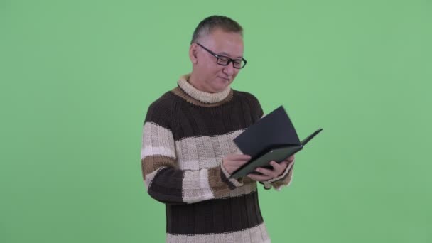 Felice maturo giapponese uomo lettura libro con occhiali da vista — Video Stock