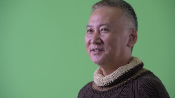 Closeup profile view of happy mature Japanese man smiling and ready for winter — Stock Video