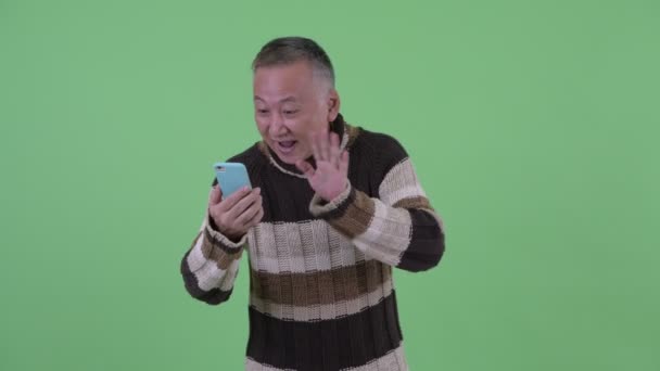 Heureux mature japonais homme vidéo appel et montrant téléphone — Video