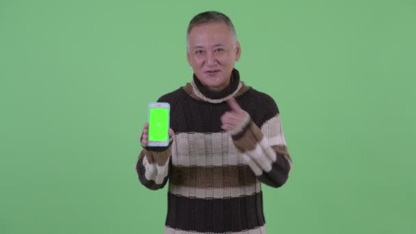 Heureux mature japonais l'homme montrant téléphone et donnant pouces jusqu "à — Video