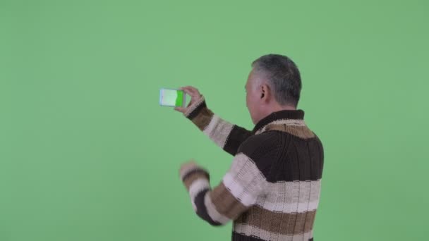 Achteraanzicht van volwassen Japanse man het nemen van foto met telefoon — Stockvideo