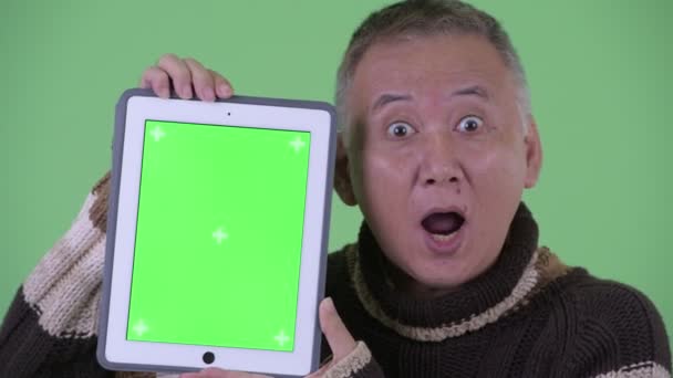 Tvář šťastného japonského muže, který mluví, když zobrazuje digitální tablet — Stock video