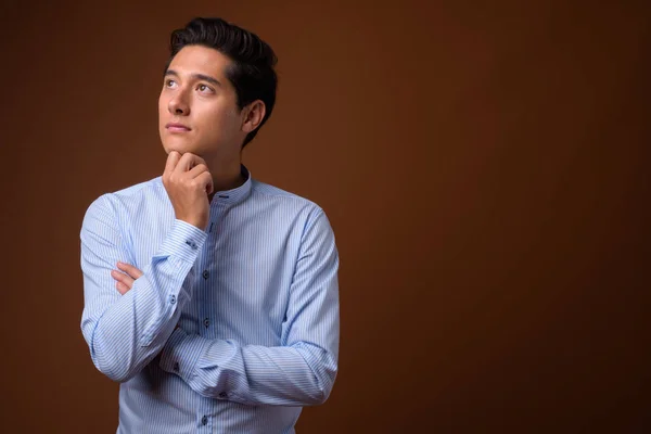 Junger multiethnischer Geschäftsmann mit braunem Hintergrund — Stockfoto