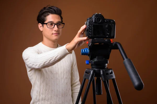 Young multi-ethnic handsome man against brown background — Stock Photo, Image