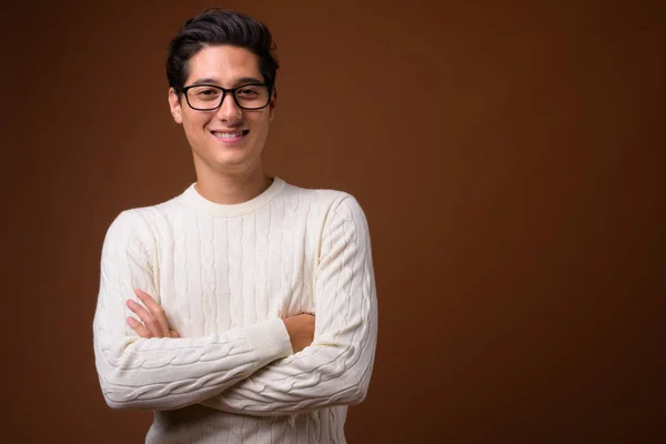 Joven hombre apuesto multiétnico contra el fondo marrón — Foto de Stock