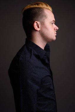 Gri ba karşı Mohawk saç modeli ve sarı saçlı işadamı