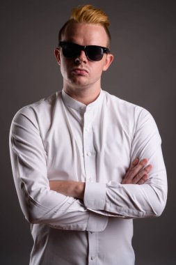 Gri ba karşı Mohawk saç modeli ve sarı saçlı işadamı