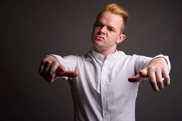 Empresário com penteado Mohawk e cabelo loiro contra ba cinza — Fotografia de Stock