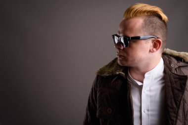 Gri arka plan karşı Mohawk saç modeli ve sarı saçlı Adam