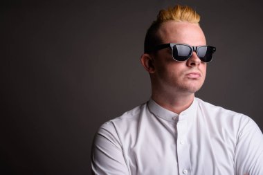 Gri ba karşı Mohawk saç modeli ve sarı saçlı işadamı