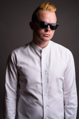 Gri ba karşı Mohawk saç modeli ve sarı saçlı işadamı