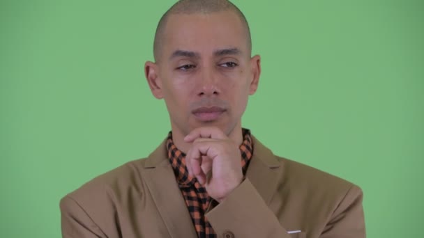 Unavený holohlavý multietnický obchodník, který přemýšlí a vypadá nudně — Stock video