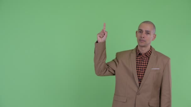 Sad bald multi ethnic businessman pointing up — Stock Video