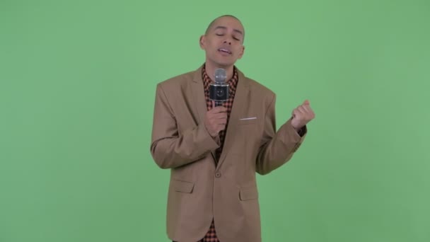 Sad bald multi ethnic businessman singing with microphone — Stock Video