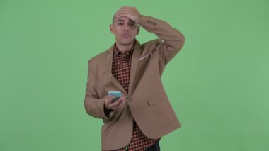Stresli kel çok ırklı işadamı telefon kullanarak ve kötü haber alıyorum