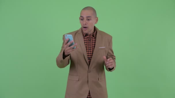 Zdůrazňoval holohlavý multietnický podnikatel, který používal telefon a vypadal šokovaně — Stock video