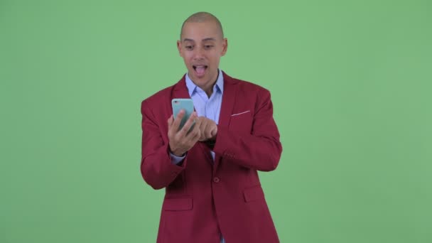 Happy bald multi ethnic businessman using phone and getting good news — Stock Video