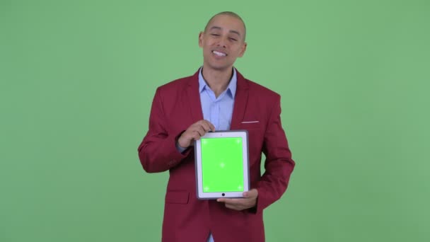 Щасливий лисий багатонаціональний бізнесмен представлення з цифровим планшетом — стокове відео