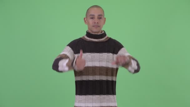 Confused bald multi ethnic man choosing between thumbs up and thumbs down — Stock Video