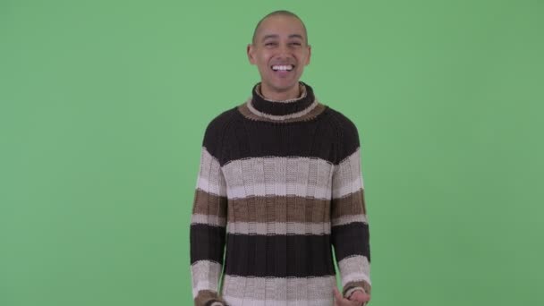 Šťastný holohlavý multietnický muž, který prezentuje něco připraveného na zimu — Stock video