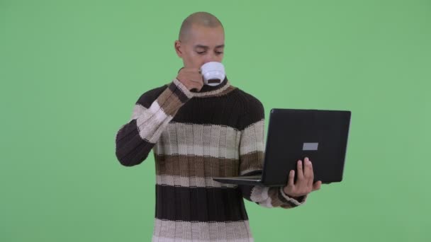 Ευτυχισμένος φαλακρός πολυεθνικός άνθρωπος σκέψης ενώ χρησιμοποιεί το laptop — Αρχείο Βίντεο
