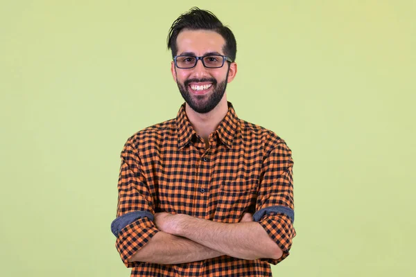 Feliz jovem barbudo persa hipster homem sorrindo com os braços cruzados — Fotografia de Stock