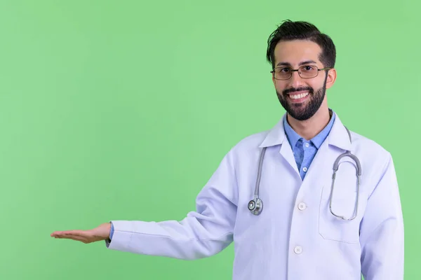 Boldog fiatal szakállas perzsa férfi orvos mutat valamit — Stock Fotó