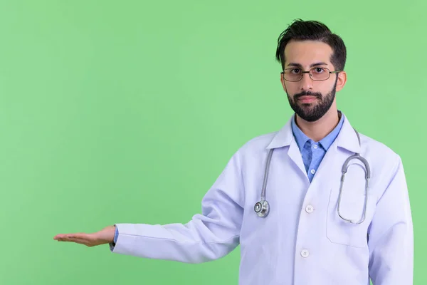 Молодой бородатый персидский врач показывает что-то — стоковое фото