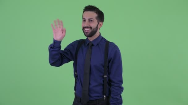 Gelukkige jonge bebaarde Perzische zakenman zwaaiende hand — Stockvideo