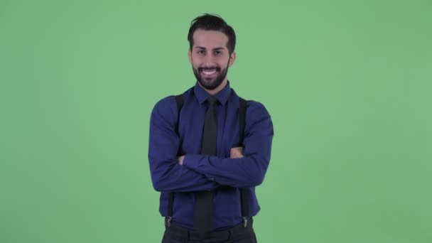 Счастливый молодой бородатый персидский бизнесмен улыбается со скрещенными руками — стоковое видео