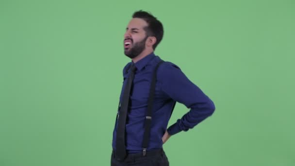 Estresado joven barbudo empresario persa que tiene dolor de espalda — Vídeos de Stock